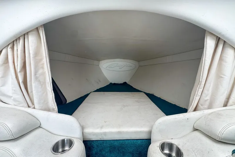 Slide: The Image of Interior cabin of 1999 Baja 29 Outlaw boat with white upholstery and blue carpet. - 54