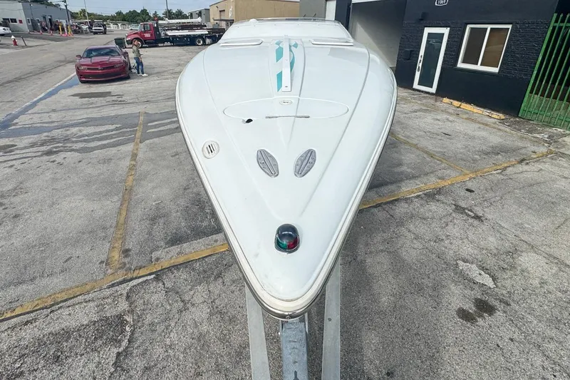 Slide: The Image of 1999 Baja 29 Outlaw boat on trailer in parking lot, front view. - 60