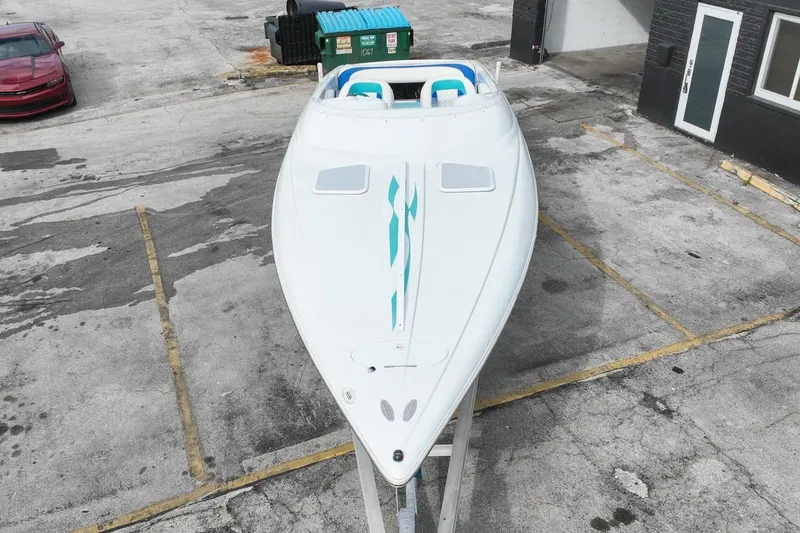 Slide: The Image of 1999 Baja 29 Outlaw speedboat on trailer in parking lot, aerial view. - 62