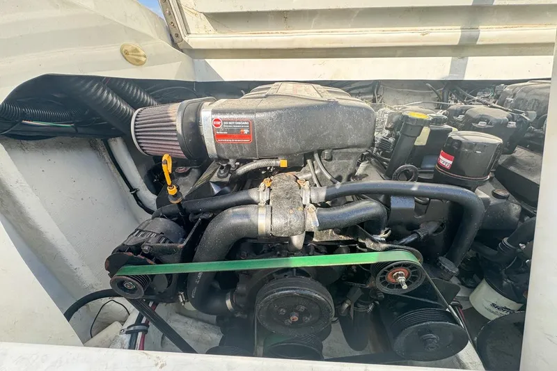 Slide: The Image of Engine compartment of a 1999 Baja 29 Outlaw boat, showcasing mechanical components. - 69