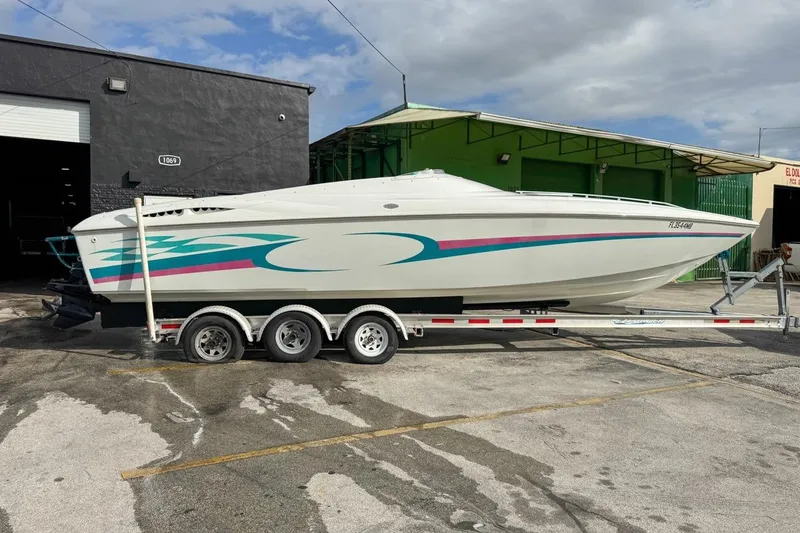 Slide: The Image of 1999 Baja 29 Outlaw speedboat on a trailer, parked outside a warehouse. - 8