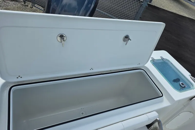 Slide: The Image of Open storage compartment on 2026 Parker 227 Explorer boat, featuring secure locks and adjacent sink. - 12