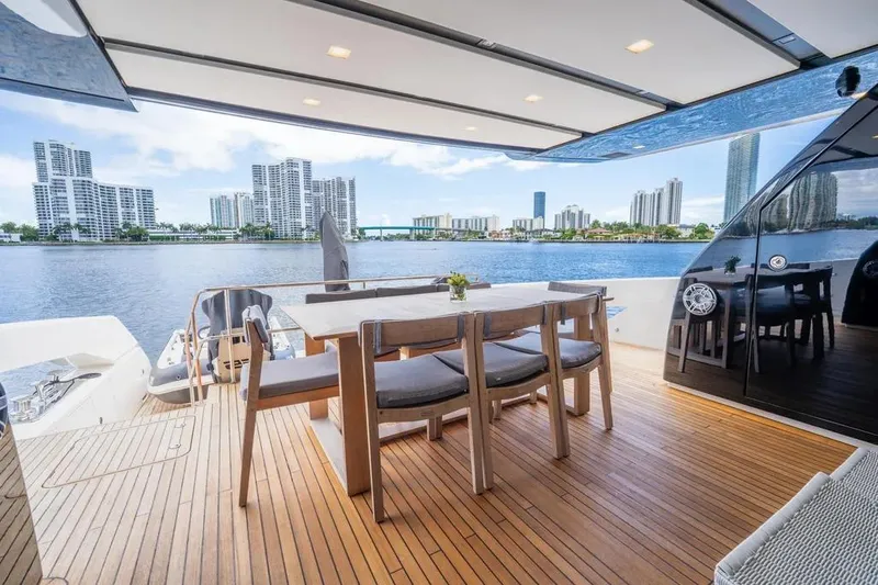 Slide: The Image of Luxurious 2021 Sanlorenzo SX76 yacht deck with dining area, overlooking waterfront cityscape. - 21