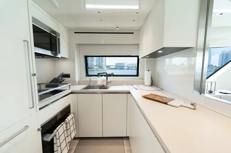 Slide: The Image of Modern kitchen interior on 2021 Sanlorenzo SX76 yacht, featuring sleek white cabinetry and appliances. - 29