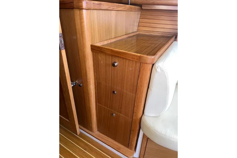 Slide: The Image of Wooden interior cabinetry in a 2016 Catalina 385 sailboat, featuring drawers and white seating. - 14