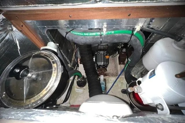 Slide: The Image of Engine compartment of a 2016 Catalina 385 sailboat, featuring hoses and mechanical components. - 18