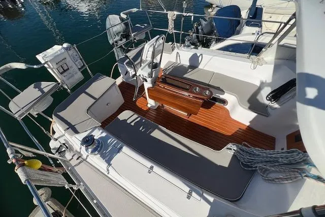 Slide: The Image of 2016 Catalina 385 sailboat cockpit with seating, wooden flooring, and steering wheel. - 20
