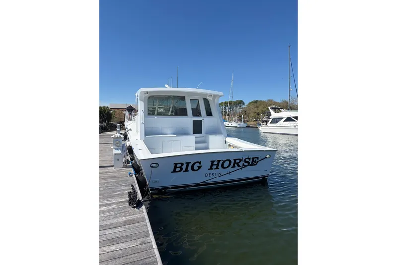 Slide: The Image of 2006 Dixon 52 boat named "Big Horse" docked in a marina under clear blue skies. - 3
