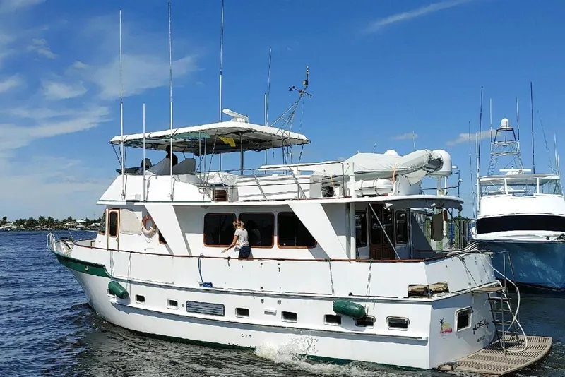 The Image of 1982 DeFever 52 Offshore Cruiser yacht on calm waters under a clear blue sky. - 0