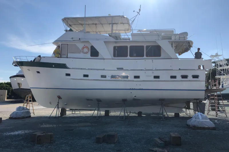 Slide: The Image of 1982 DeFever 52 Offshore Cruiser yacht on dry dock under clear blue sky. - 10