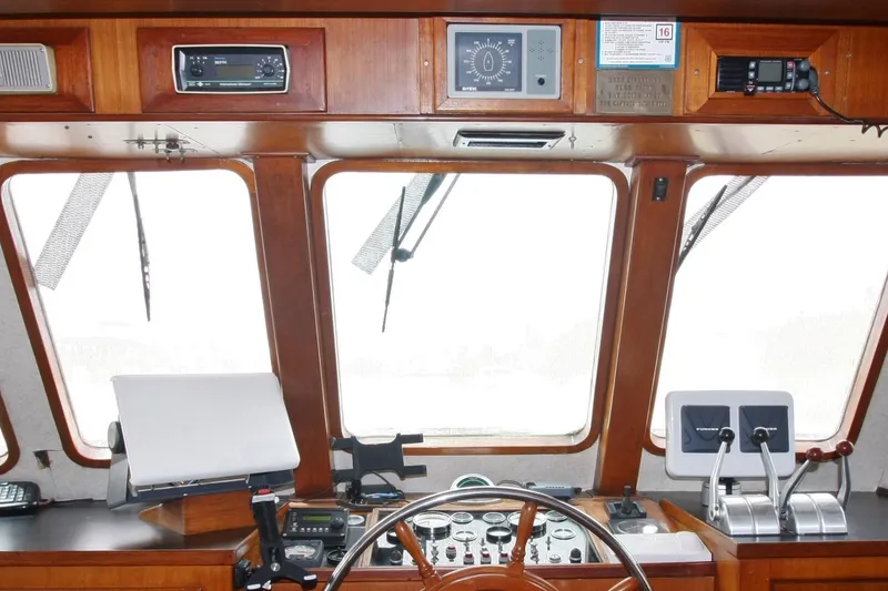 Slide: The Image of 1982 DeFever 52 Offshore Cruiser helm with wooden dashboard and navigation instruments. - 19