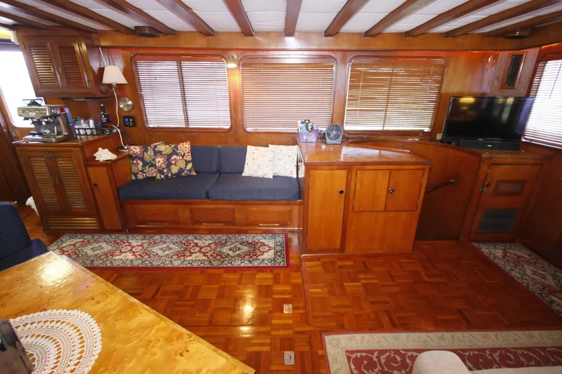 Slide: The Image of Interior of 1982 DeFever 52 Offshore Cruiser with wood paneling and cozy seating area. - 25