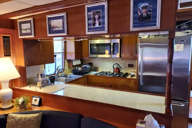 Slide: The Image of Interior of 1982 DeFever 52 Offshore Cruiser with kitchen and framed photos. - 36