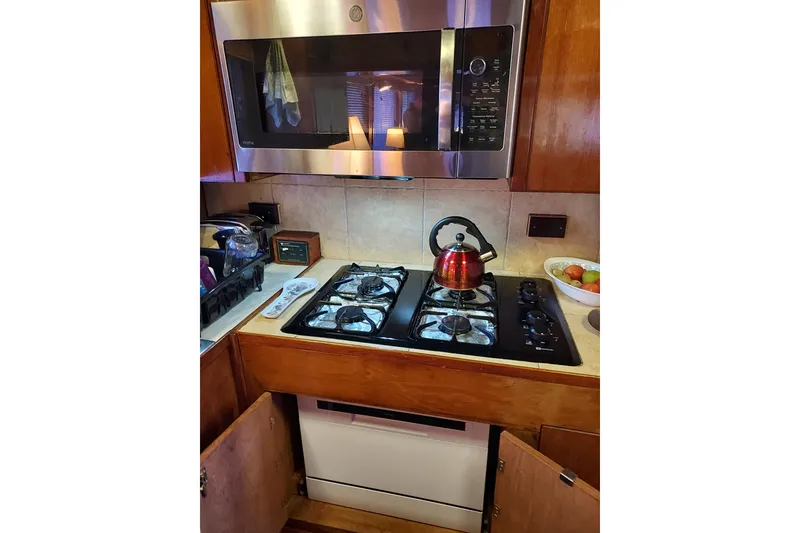 Slide: The Image of Galley kitchen in 1982 DeFever 52 Offshore Cruiser with stove, microwave, and kettle. - 37