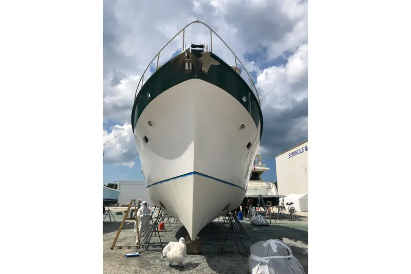 Slide: The Image of 1982 DeFever 52 Offshore Cruiser in shipyard, undergoing maintenance under cloudy sky. - 4