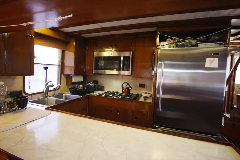 Slide: The Image of 1982 DeFever 52 Offshore Cruiser kitchen with stainless steel appliances and wooden cabinetry. - 40
