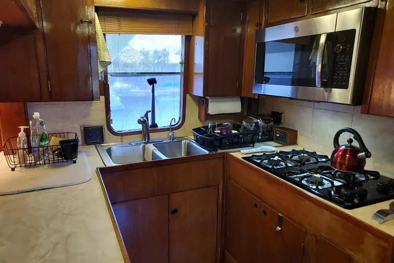 Slide: The Image of 1982 DeFever 52 Offshore Cruiser kitchen with wooden cabinets, stove, and microwave. - 42