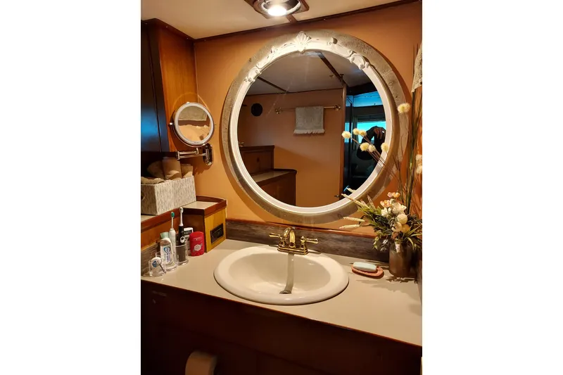 Slide: The Image of Elegant bathroom on 1982 DeFever 52 Offshore Cruiser with round mirror and floral decor. - 50