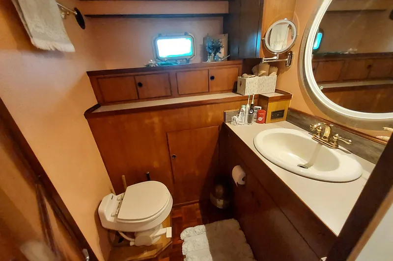 Slide: The Image of 1982 DeFever 52 Offshore Cruiser bathroom with wooden cabinetry and oval mirror. - 51