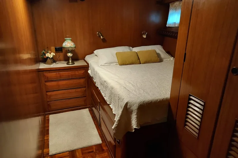 Slide: The Image of Cozy bedroom interior of 1982 DeFever 52 Offshore Cruiser with wood paneling and elegant decor. - 58
