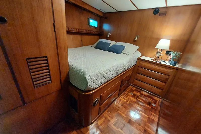 Slide: The Image of 1982 DeFever 52 Offshore Cruiser cabin with wooden interior, cozy bed, and ambient lighting. - 59