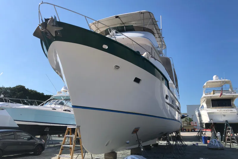 Slide: The Image of 1982 DeFever 52 Offshore Cruiser yacht on dry dock under clear blue sky. - 6