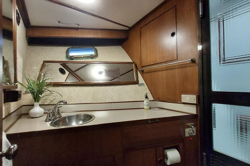 Slide: The Image of 1982 DeFever 52 Offshore Cruiser bathroom with wood paneling and stainless steel sink. - 60
