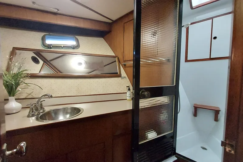 Slide: The Image of 1982 DeFever 52 Offshore Cruiser bathroom with sink, mirror, and shower. - 61