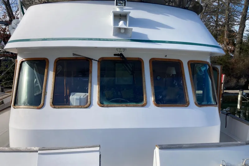Slide: The Image of 1982 DeFever 52 Offshore Cruiser boat with large windows and white exterior. - 68