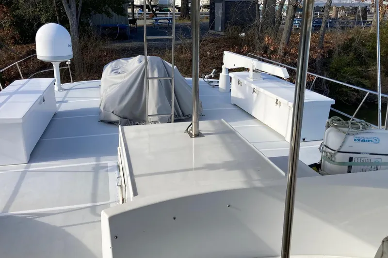 Slide: The Image of 1982 DeFever 52 Offshore Cruiser deck with storage boxes and covered equipment. - 69