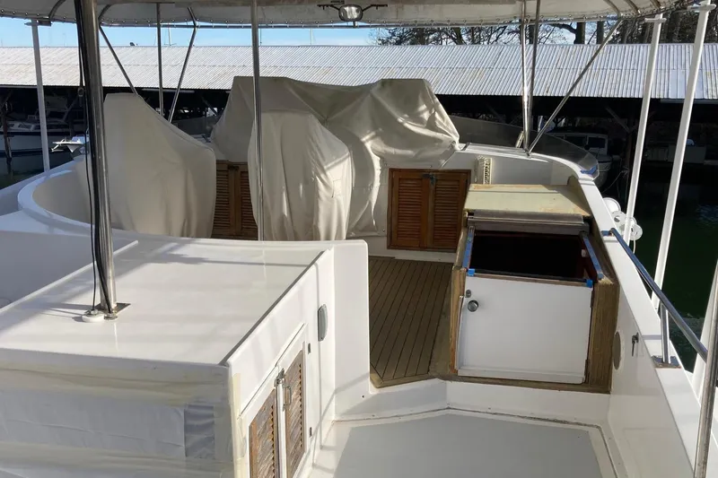 Slide: The Image of 1982 DeFever 52 Offshore Cruiser deck with covered seating and storage areas. - 70