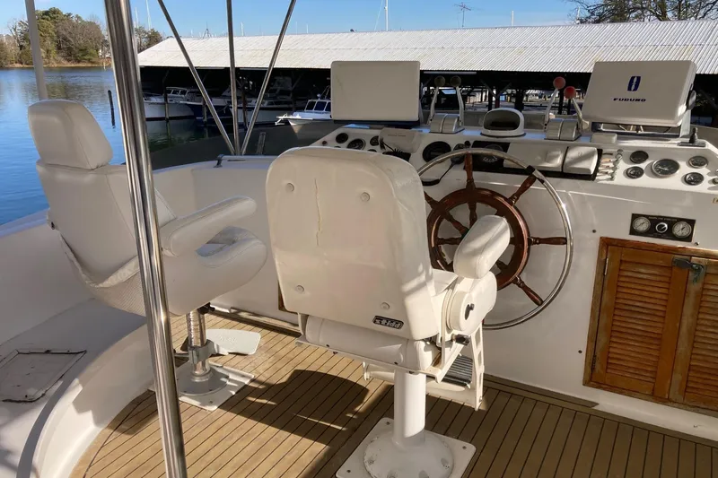 Slide: The Image of 1982 DeFever 52 Offshore Cruiser helm with wooden wheel and navigation equipment. - 73