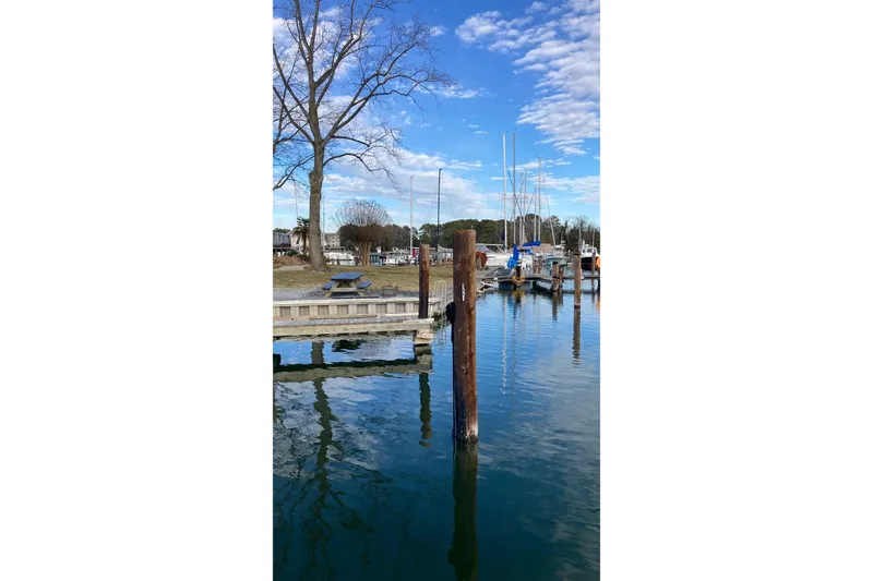 Slide: The Image of Marina with boats docked, clear blue sky, and reflections on water. - 75