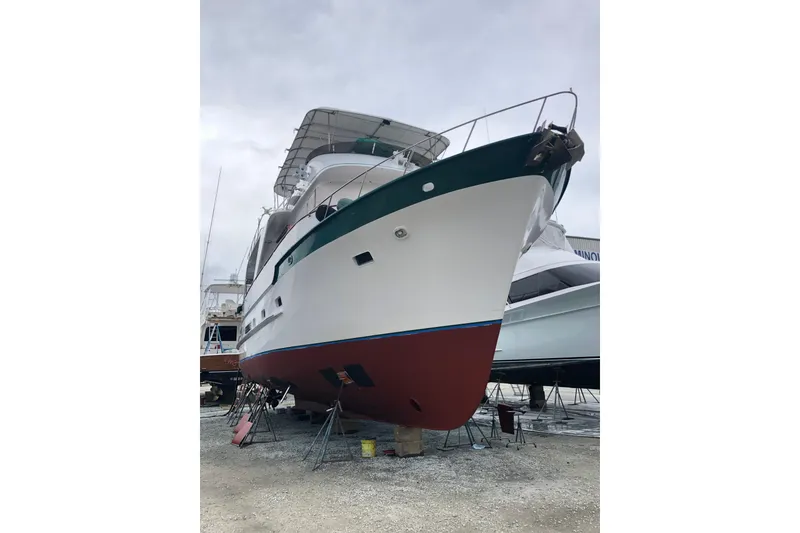 Slide: The Image of 1982 DeFever 52 Offshore Cruiser yacht on dry dock, showcasing its hull and structure. - 8