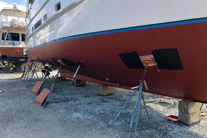 Slide: The Image of 1982 DeFever 52 Offshore Cruiser on stands, undergoing maintenance in a boatyard. - 9