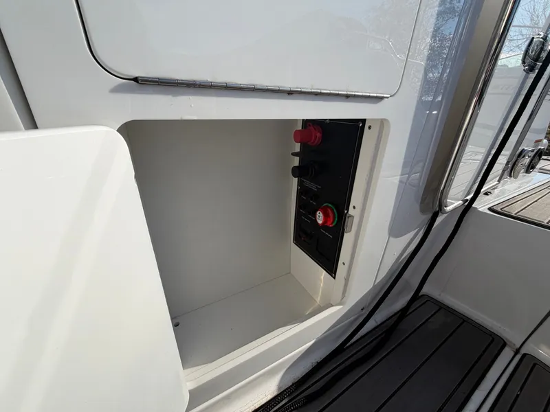 Slide: The Image of 2023 Monterey M6 boat, open storage compartment with switches. - 32