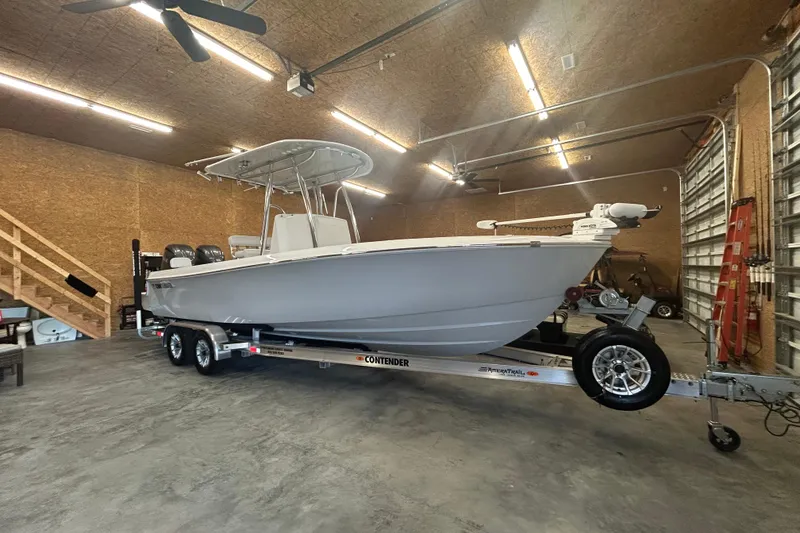 The Image of 2024 Contender 24 Sport boat on trailer in spacious garage. - 1