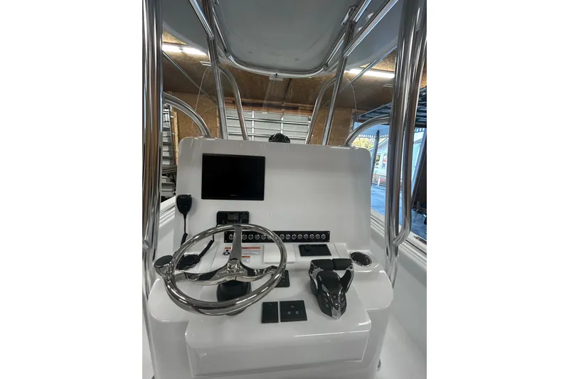 Slide: The Image of 2024 Contender 24 Sport boat console with steering wheel and controls. - 10