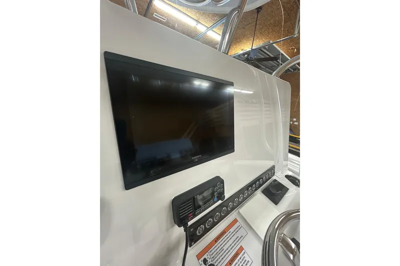 Slide: The Image of 2024 Contender 24 Sport boat dashboard with Garmin display and control panel. - 11
