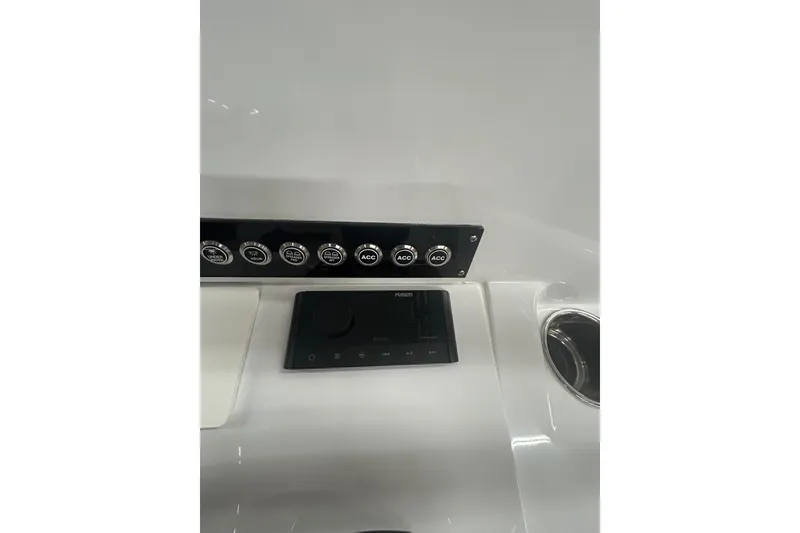 Slide: The Image of 2024 Contender 24 Sport dashboard with control panel and cup holder. - 13