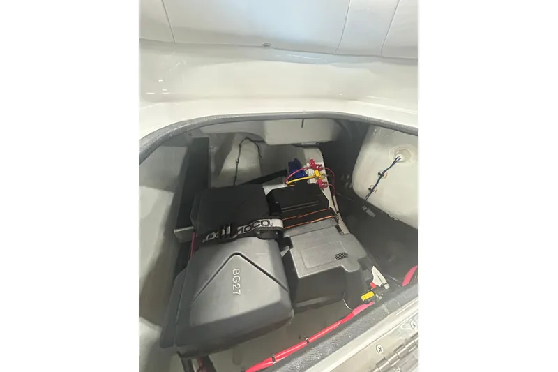 Slide: The Image of 2024 Contender 24 Sport boat battery compartment with wiring and components. - 16