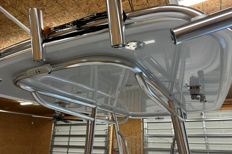 Slide: The Image of 2024 Contender 24 Sport boat T-top with stainless steel rod holders in a garage. - 20