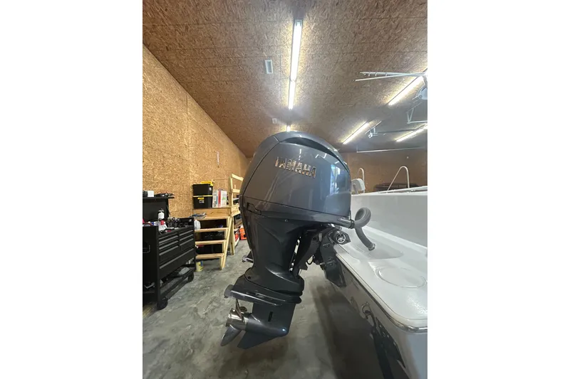 Slide: The Image of 2024 Contender 24 Sport boat with Yamaha outboard motor in a garage setting. - 3