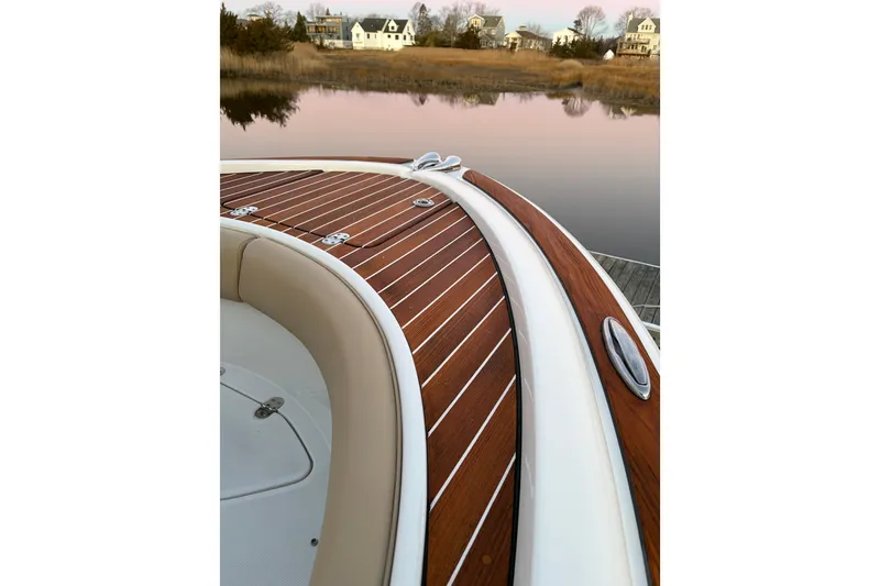 Slide: The Image of 2019 Chris-Craft Catalina 26 boat with elegant wooden deck, docked by serene waters. - 13