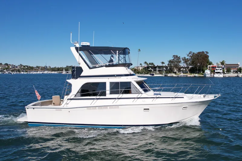 The Image of 1985 Chris-Craft 382 Commander yacht cruising on a sunny day, with clear blue skies. - 0