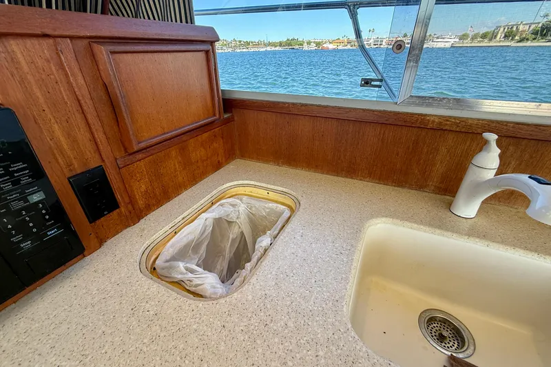 Slide: The Image of 1985 Chris-Craft 382 Commander kitchen with sink, trash compartment, and water view. - 18