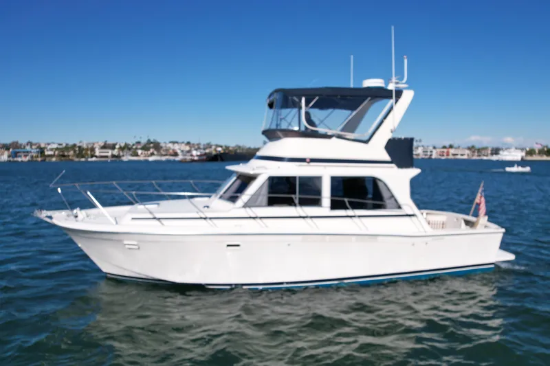 Slide: The Image of 1985 Chris-Craft 382 Commander yacht on calm water under clear blue sky. - 2