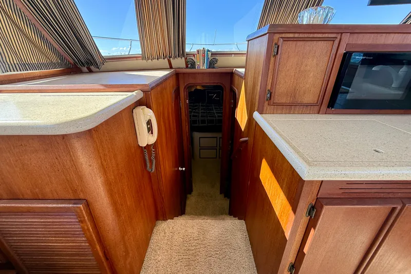 Slide: The Image of 1985 Chris-Craft 382 Commander interior with wood cabinetry and beige countertops. - 21