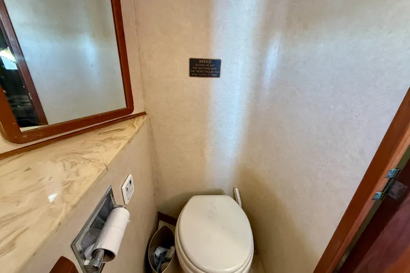 Slide: The Image of 1985 Chris-Craft 382 Commander bathroom with toilet, mirror, and marble countertop. - 29