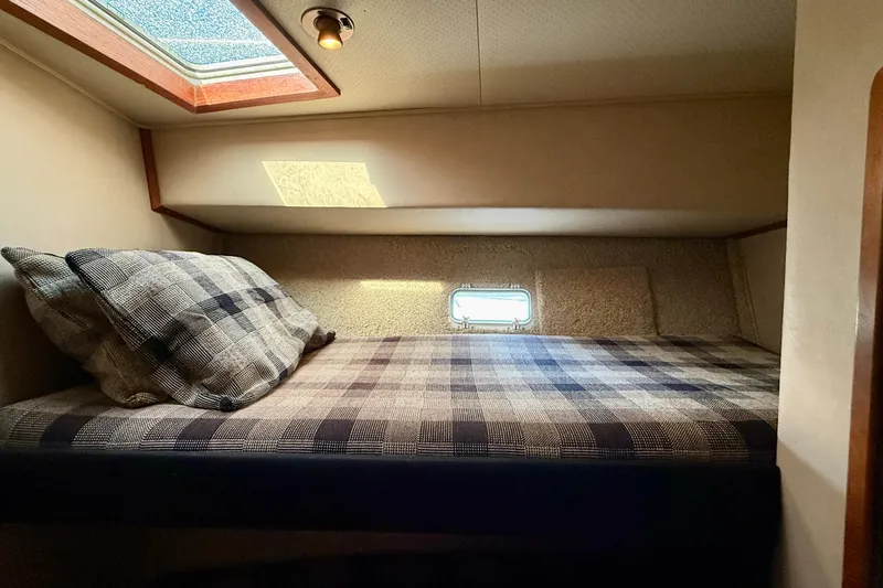 Slide: The Image of Cozy cabin interior of 1985 Chris-Craft 382 Commander with plaid bedding and natural light. - 31
